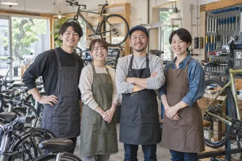 作業用のエプロンをつけた店員たちの集合写真（自転車販売・修理の写真 No.47）