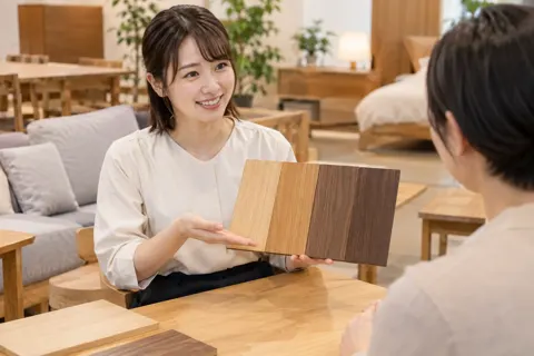木の色の見本を見せる店員（家具の写真 No.21）