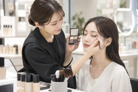 アイシャドウをお客様のまぶたにのせる店員（コスメ・化粧品の写真 No.29）