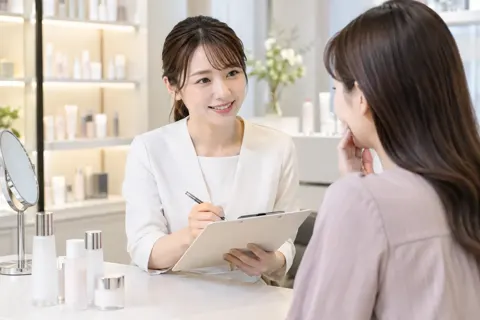 肌のなやみを聞いてカルテに書く店員（コスメ・化粧品の写真 No.31）