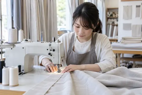 ミシンでカーテンをぬう職人（寝具・カーテンの写真 No.25）