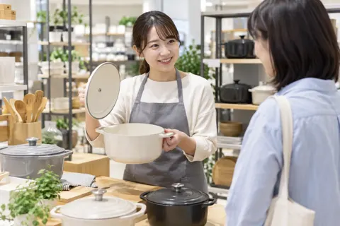 なべのふたを開けて説明する店員（食器・キッチン用品の写真 No.20）