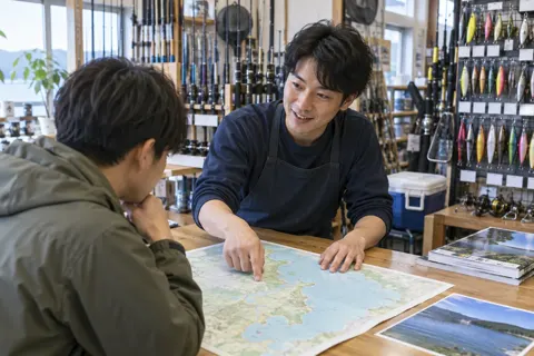 つりの場所を地図で教える店員（釣具店・フィッシング用品の写真 No.22）