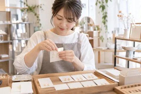 アクセサリーを台紙につける店員（雑貨・インテリア小物の写真 No.31）