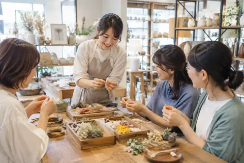 店の中の机で小物を作る講習をする店員と参加者たち（雑貨・インテリア小物の写真 No.43）