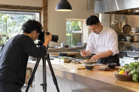 料理人の調理を撮影するカメラマン（映像制作の写真 No.20）