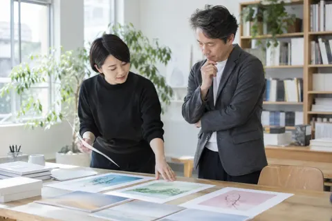 デザイナーと表紙の案を見くらべる編集者（出版・編集・ライターの写真 No.20）
