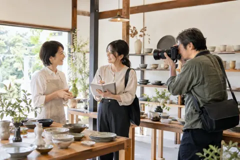 カメラマンと一緒に店を取材するライター（出版・編集・ライターの写真 No.25）